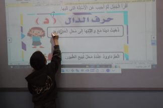 Oppilas kirjottaa taululle.